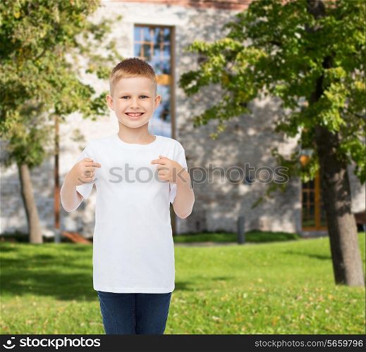 advertising, gesture, people and childhood concept - smiling boy in white blank t-shirt pointing fingers at himself over campus background