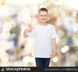 advertising, gesture, people and childhood concept - smiling boy in white blank t-shirt pointing finger himself over holidays background