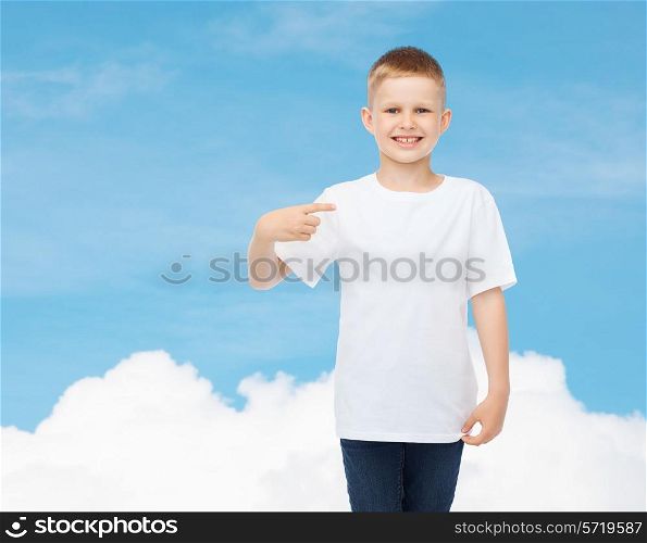 advertising, gesture, people and childhood concept - smiling little boy in white t-shirt pointing finger at himself over sky background