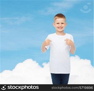 advertising, gesture, people and childhood concept - smiling little boy in white t-shirt pointing fingers at himself over sky background