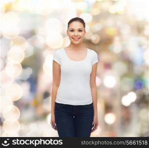 advertising, holidays and people concept - smiling young woman in blank white t-shirt over sparkling background