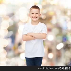 advertising, holidays, party, people and childhood concept - smiling little boy in white blank t-shirt over sparkling background