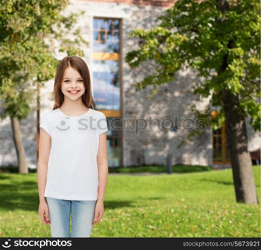 advertising, leisure, summer vacation, childhood and people - smiling little girl in white blank t-shirt over campus background