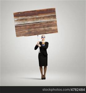 Advertising manager. Image of businesswoman holding blank wooden banner. Place for text