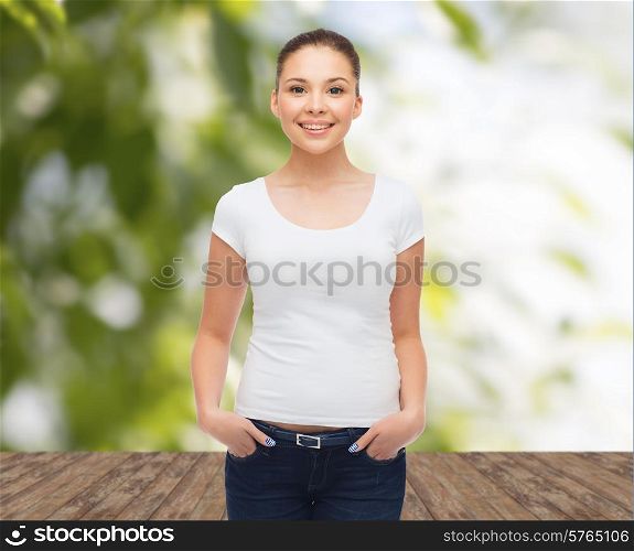 advertising, nature, ecology, summer vacation and people concept - smiling young woman in blank white t-shirt over wooden floor and green plants background
