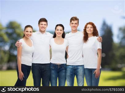 advertising, nature, summer holidays and people concept - group of smiling teenagers in white blank t-shirts