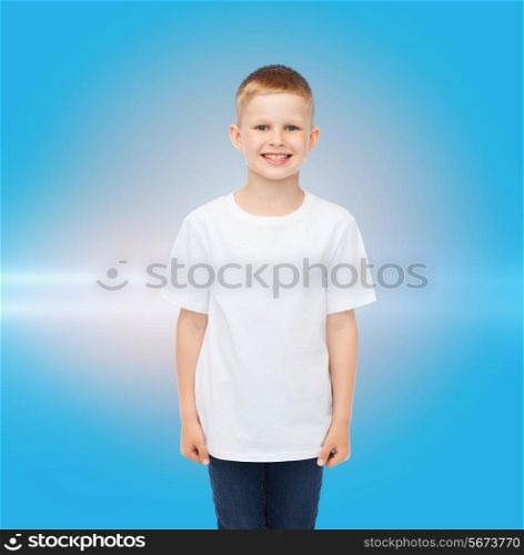 advertising, people, childhood and people concept - smiling little boy in white blank t-shirt over blue background with laser light