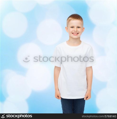 advertising, people, childhood and people concept - smiling little boy in white blank t-shirt over blue background