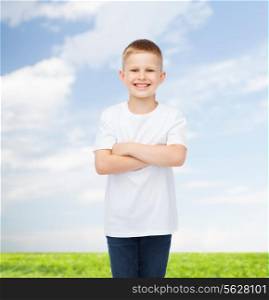 advertising, people, summer and childhood concept - smiling little boy in white blank t-shirt over natural background