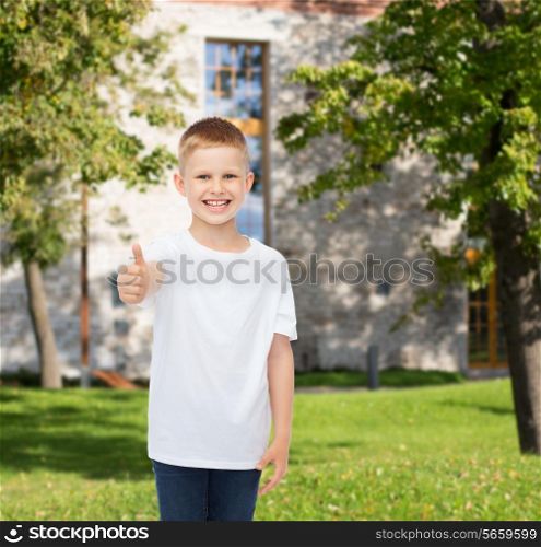 advertising, summer, gesture, people and childhood concept - smiling little boy in white blank t-shirt over campus background