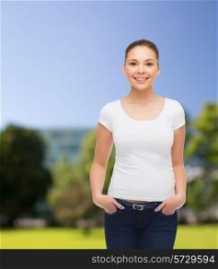 advertising, summer vacation and people concept - smiling young woman in blank white t-shirt over park background