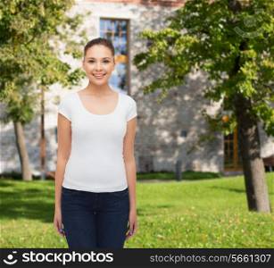 advertising, summer vacation, education and people concept - smiling young woman in blank white t-shirt over campus background