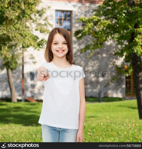 advertising, summer vacation, gesture, childhood and people - smiling girl in white t-shirt pointing finger on you over campus background