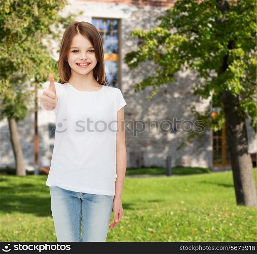 advertising, summer vacation, gesture, childhood and people - smiling little girl in white t-shirt showing thumbs up over campus background