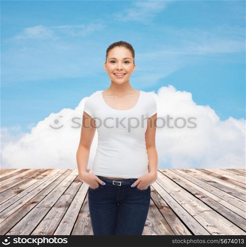 advertising, vacation and people concept - smiling young woman in blank white t-shirt over wooden berth and blue sky background