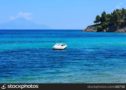 Aegean sea coast landscape with motor boat in bay, view near Karidi beach (Chalkidiki, Greece).