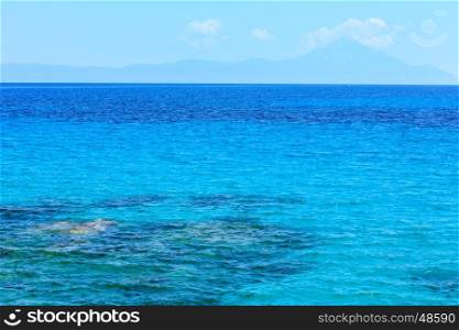 Aegean sea landscape with clear water and small waves and Mount Athos in mist (Chalkidiki, Greece).