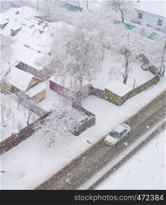 Aerail view of residential area with car on road and privat houses in snowfall winter day, Kiev, Ukraine