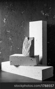 Aerated concrete block cube or bricks near plaster wall background texture. Construction concept of minimalism design