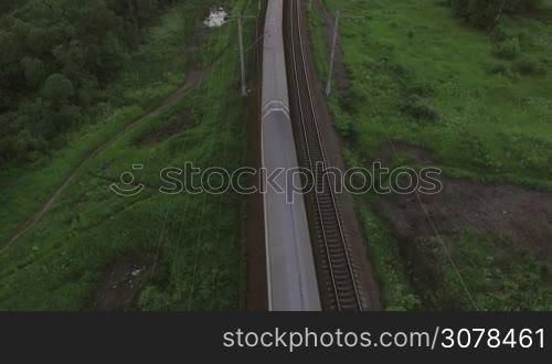 Aerial bird eye view of two railway different direction and moving freight and passengers trains in countryside, Russia