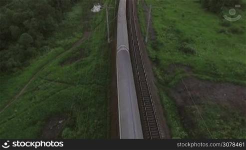 Aerial bird eye view of two railway different direction and moving freight and passengers trains in countryside, Russia