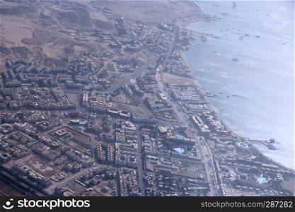 Aerial city view with houses, buildings, seaside in Egypt. Flying above country. Panoramic image. Egyptian town seen from above. Egyptial town from sky. Aerial panorama of town on seaside. Aerial city view with houses, buildings, seaside in Egypt. Flying above country