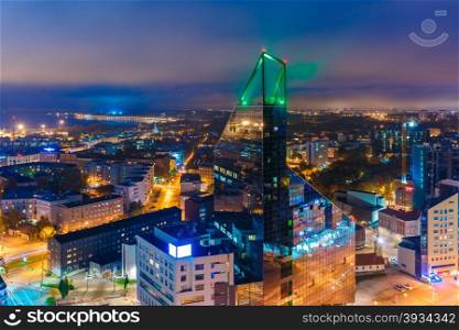 Aerial cityscape of modern business financial district with tall skyscraper buildings illuminated at night, Tallinn, Estonia