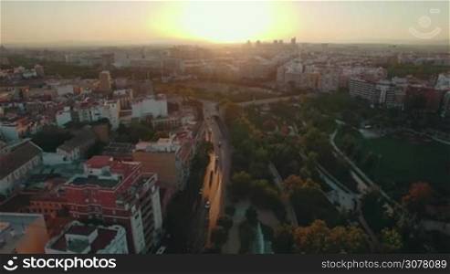 Aerial cityscape of Valencia at sunset, Spain. City panorama with houses, transport traffic and green parks with sports grounds