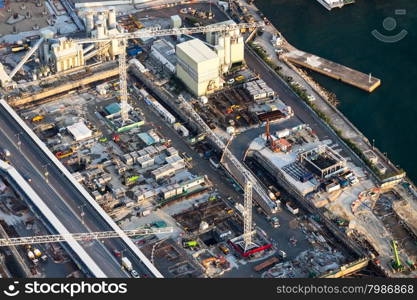 Aerial cityscape view with crane working at building construction near the harbor. Hong Kong. Abstract futuristic cityscape