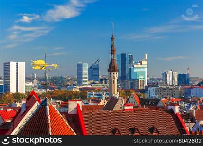 Aerial cityscape with old town hall spire, roofs, golden weather vane and modern office buildings skyscrapers in the background in Tallinn in the day, Estonia