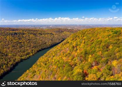 Aerial drone image of the Cheat River flowing through narrow wooded gorge in the autumn towards Cheat Lake near Morgantown, WV. Narrow gorge of the Cheat River looking down towards the lake in West Virginia with fall colors