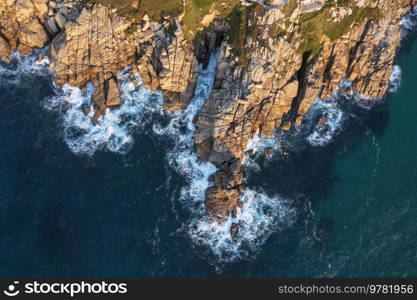 Aerial drone landscape image of Minnack Theatre headland around Porthcurno beach in Cornwall England at sunrise