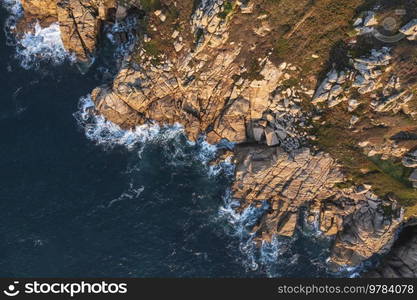 Aerial drone landscape image of Minnack Theatre headland around Porthcurno beach in Cornwall England at sunrise