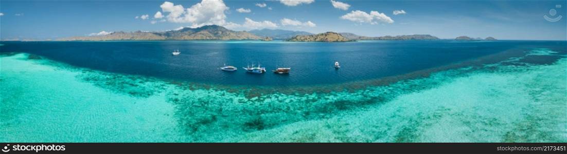 Aerial drone panoramic shot ocean, Komodo background. Transparent turquoise water of the Pacific ocean with the boats taken for tourist reasons. Komodo National Park, Indonesia.. Close-up ocean water. Komodo. Aerial drone shot.