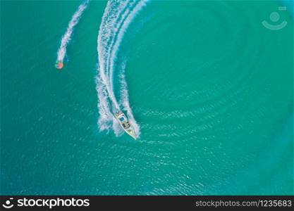Aerial drone photo of extreme powerboat donut water-sports cruising in high speed in tropical turquoise bay. Thailand, Phuket, Kata beach