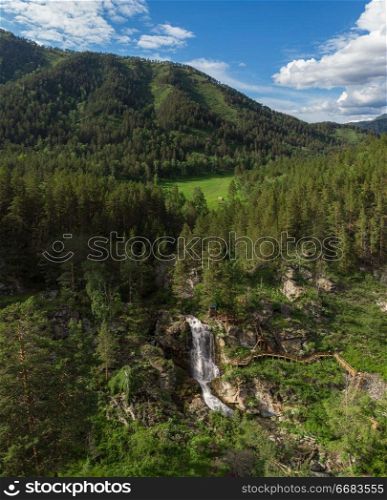 Aerial drone photo of view of waterfall in the Altai Mountains, Siberia, Russia. woman portrait in the garden of apple
