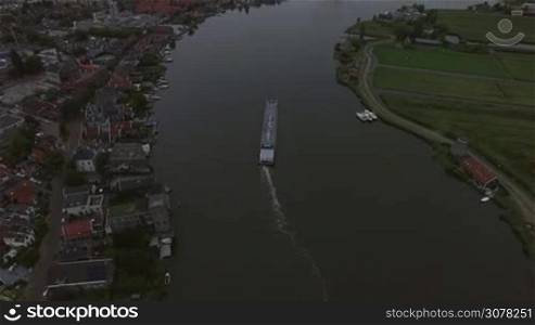 Aerial - Dutch town scene in the evening with river and sailing barge