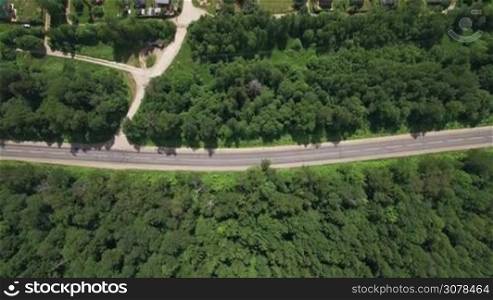Aerial flight above the countryside in Russia. Top view of country houses, road and routes between there in sunlight, Moscow, Russia