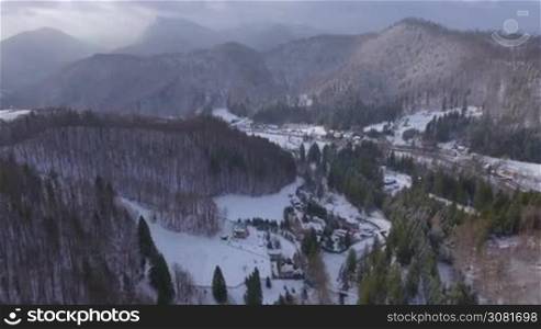 Aerial footage of small village in the mountains in winter.