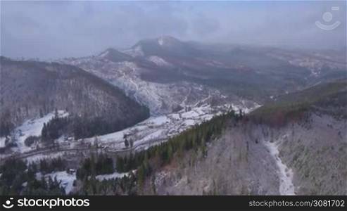 Aerial footage of small village in the mountains in winter.
