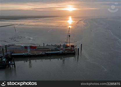 Aerial from the harbor in Holwerd with work in progress in the Netherlands at sunset
