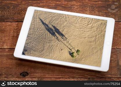 aerial landscape photography concept - reviewing aerial picture of sand dunes with lonely aspen trees on a digital tablet