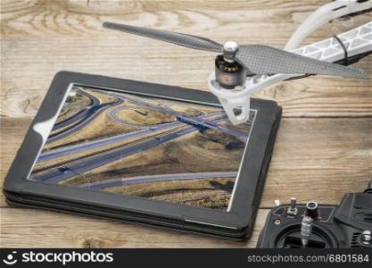 aerial landscape photography concept - reviewing aerial pictures of a freeway in Colorado on a digital tablet with a drone rotor, screen picture copyright by the photographer