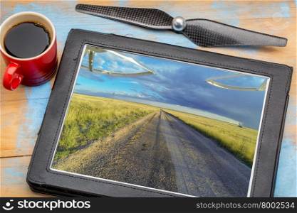 aerial landscape photography concept - reviewing aerial pictures of a prairie in Colorado on a digital tablet with a drone propeller and coffee, screen picture copyright by the photographer