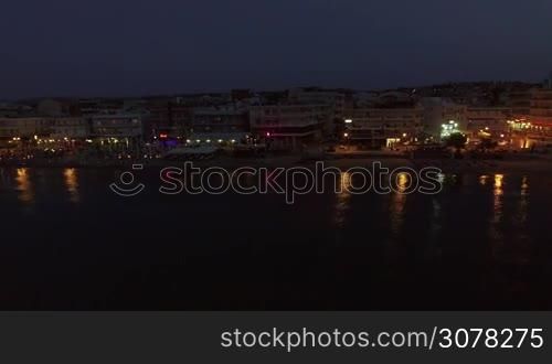 Aerial night shot of the coast with hotels, cafes, and chaise-longues alongside. Resort in Thessaloniki, Greece