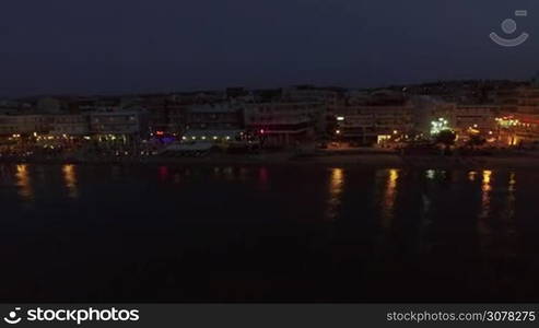 Aerial night shot of the coast with hotels, cafes, and chaise-longues alongside. Resort in Thessaloniki, Greece