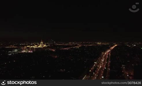 Aerial night view of the Leninsky Avenue, Moscow, Russia. Big traffic road in lights, university, buildings. View on the Lomonosov Moscow State University on the background