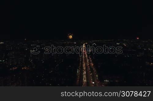 Aerial night view of the Leninsky Avenue, Moscow, Russia. Big traffic road in lights, university, buildings and sparkling fireworks in different places