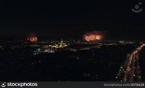 Aerial night view of the Leninsky Avenue, Moscow, Russia. Big traffic road in lights, buildings and sparkling fireworks in different places. View on the Lomonosov State University on the background