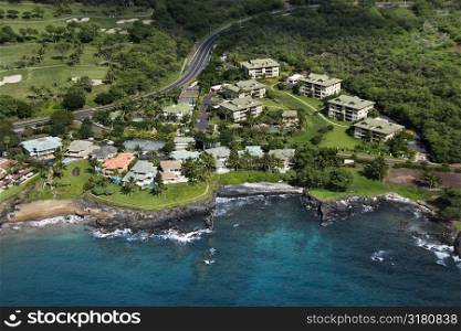 Aerial of houses clustered by Maui, Hawaii coast.